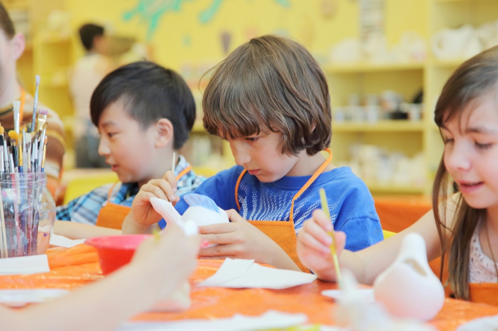 Children working on a craft project side by side