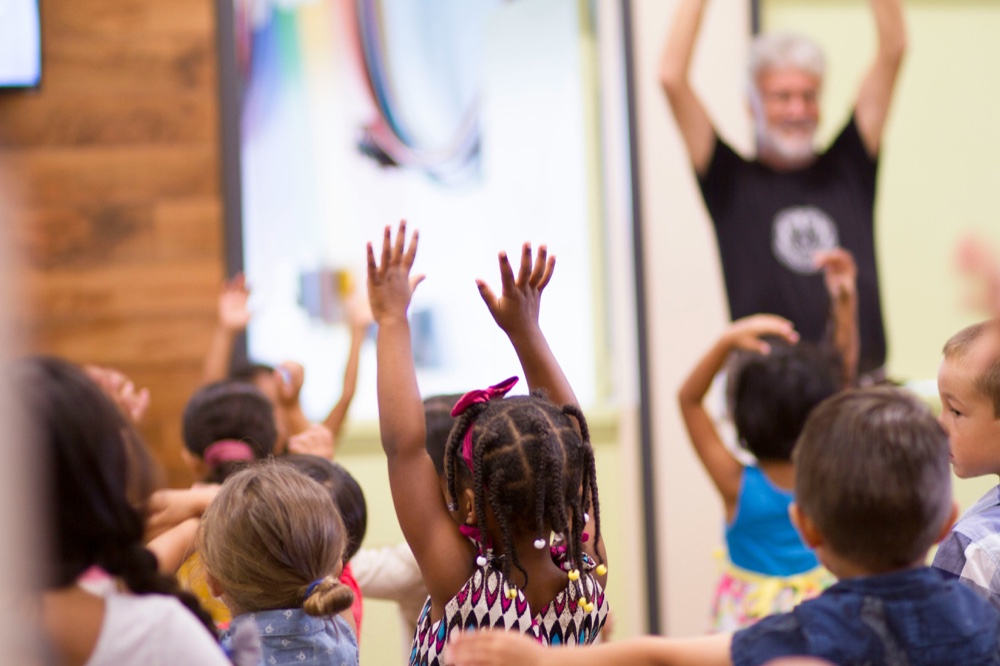 Children reaching their hands up during a group activity