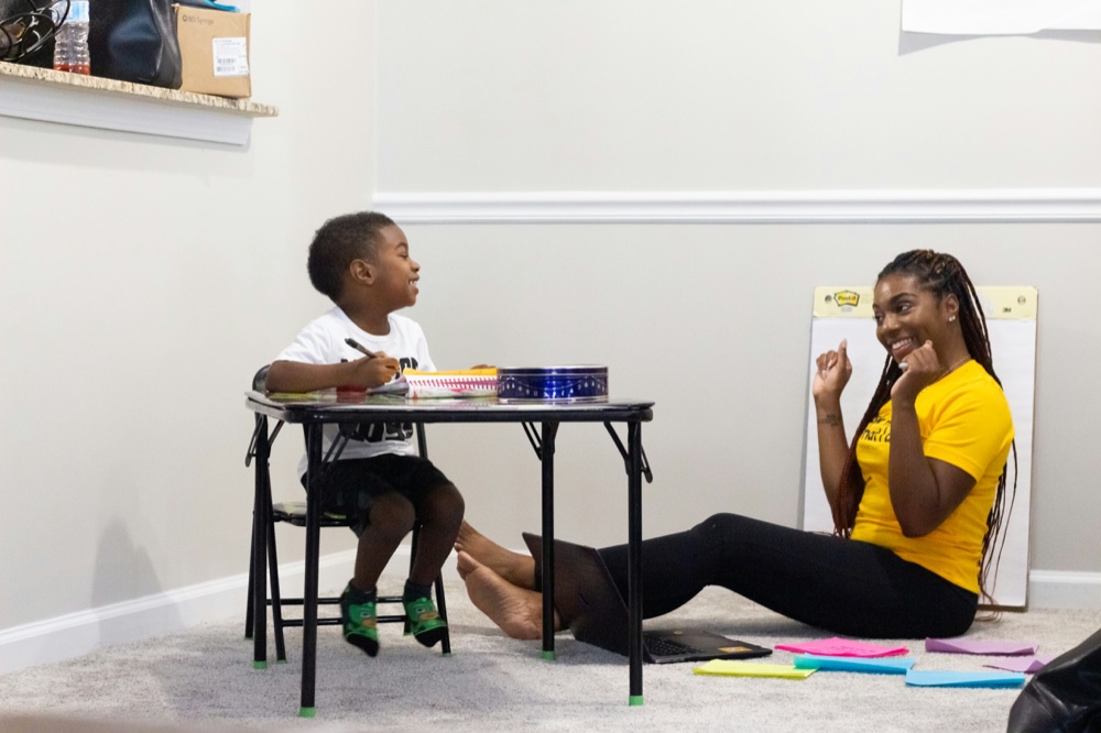 An adult and a child working together at a small table
