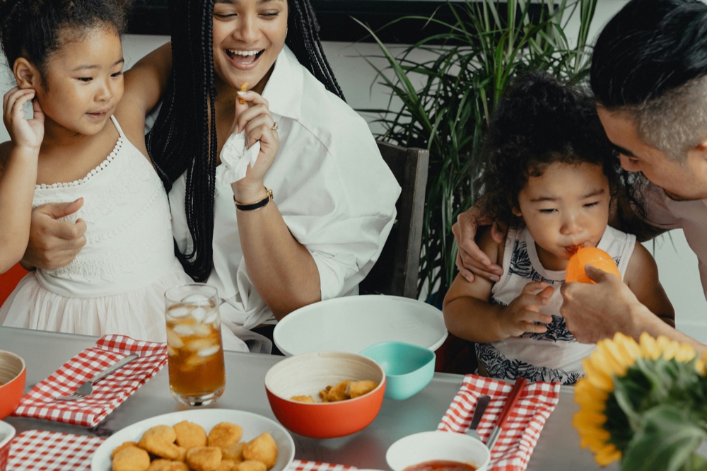 A family sharing a meal together at an outdoor table